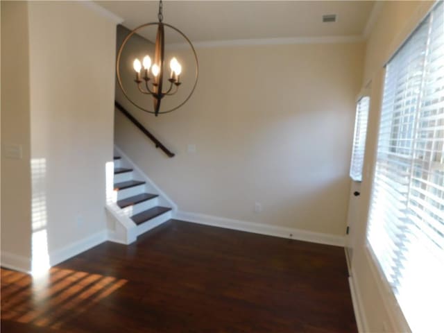 interior space featuring crown molding, stairway, an inviting chandelier, and wood finished floors