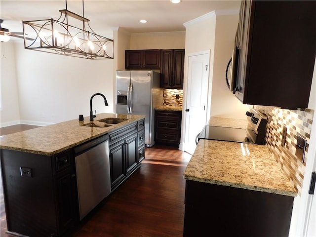 kitchen featuring dark wood-style flooring, light stone countertops, stainless steel appliances, crown molding, and a sink