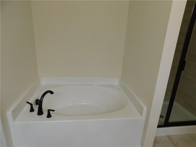 bathroom featuring a stall shower and a garden tub