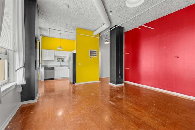 unfurnished living room featuring wood-type flooring and a textured ceiling