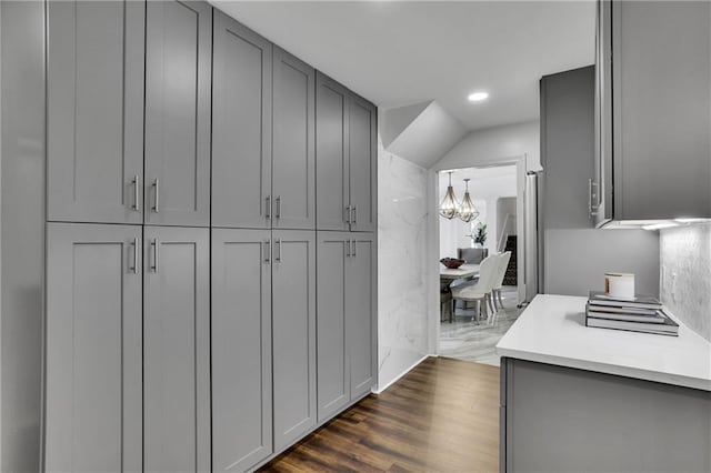 kitchen with dark wood-type flooring, a chandelier, and gray cabinetry