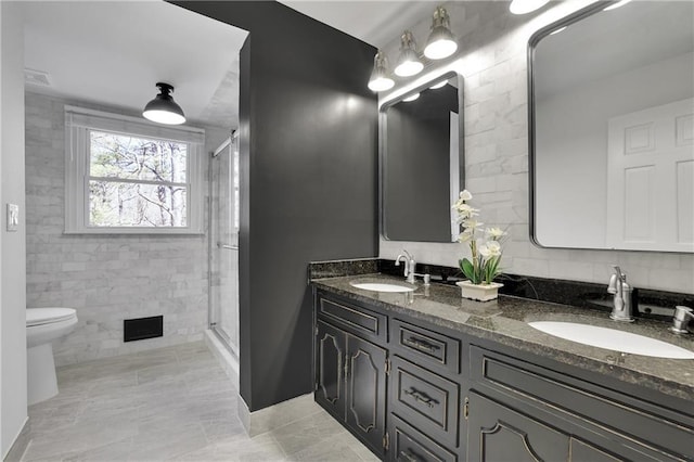 bathroom with tile walls, vanity, an enclosed shower, tile patterned floors, and toilet