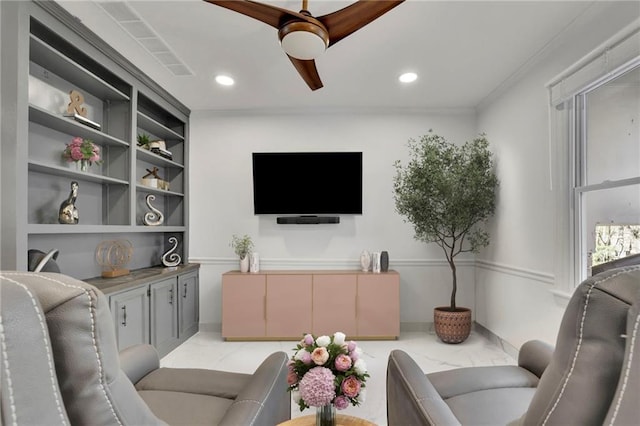 living room with crown molding, built in features, and ceiling fan