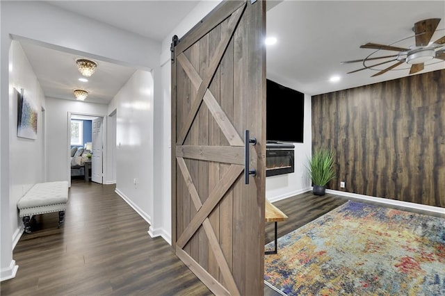 entrance foyer with dark wood-type flooring, a barn door, and ceiling fan