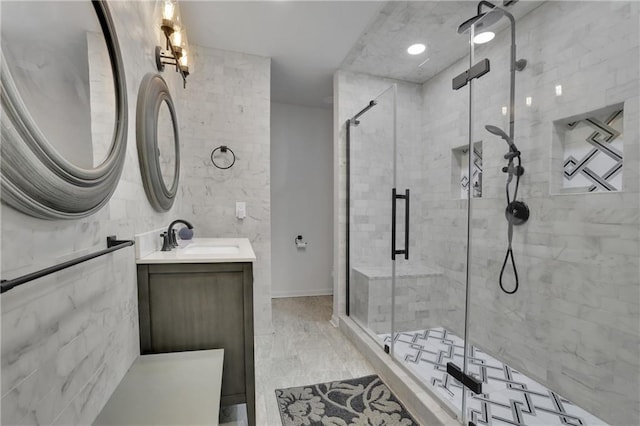 bathroom with vanity, tile walls, and an enclosed shower