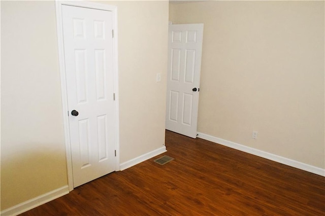 spare room with dark wood-type flooring