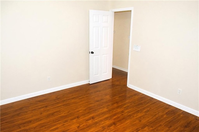 empty room with dark hardwood / wood-style flooring