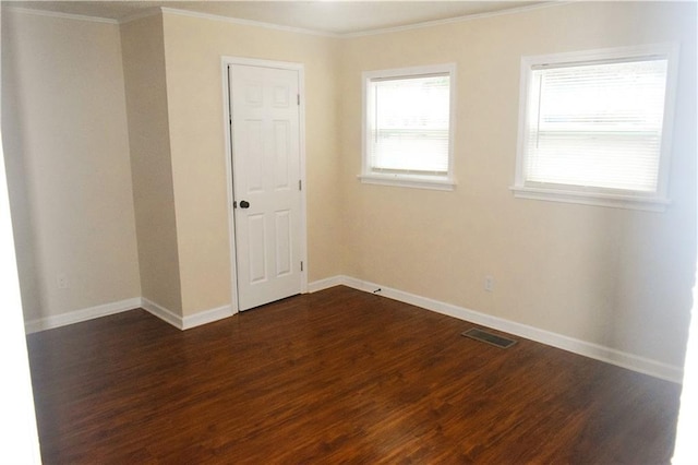 spare room featuring dark wood-type flooring and ornamental molding