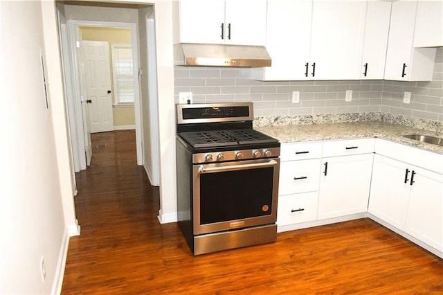 kitchen featuring range hood, gas stove, white cabinets, and tasteful backsplash