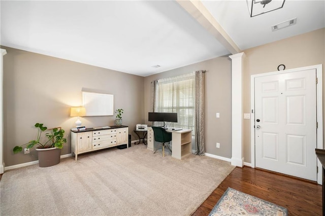 carpeted office space featuring beamed ceiling and ornate columns