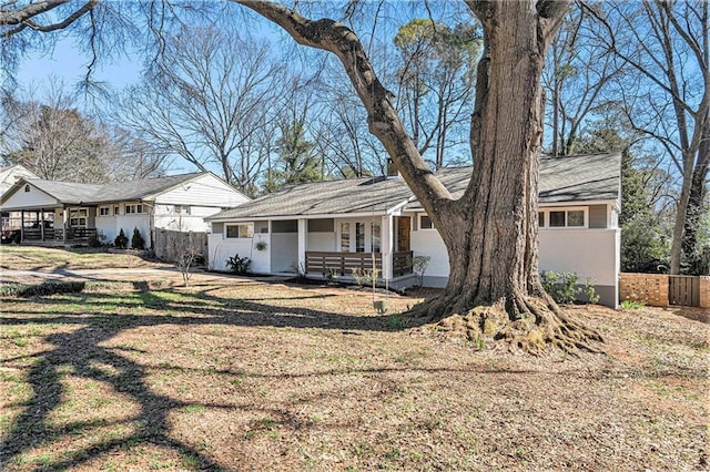 view of front of house with covered porch and fence