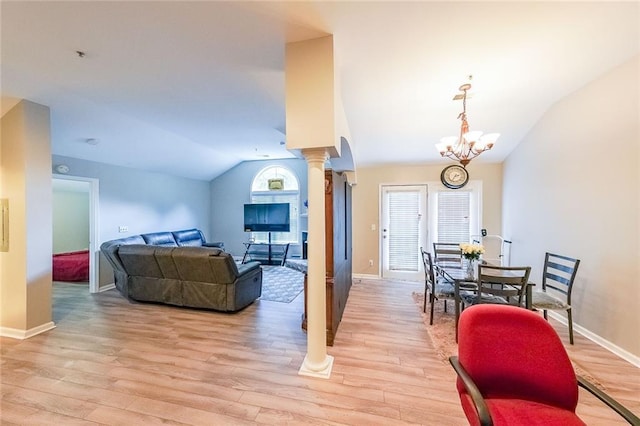 living room featuring light wood finished floors, decorative columns, baseboards, an inviting chandelier, and vaulted ceiling