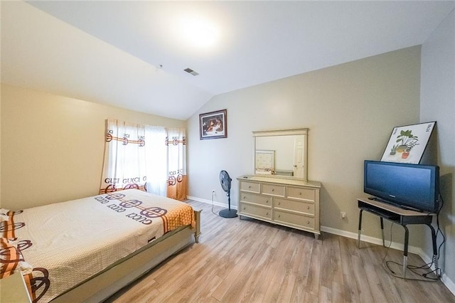 bedroom with lofted ceiling, wood finished floors, and baseboards