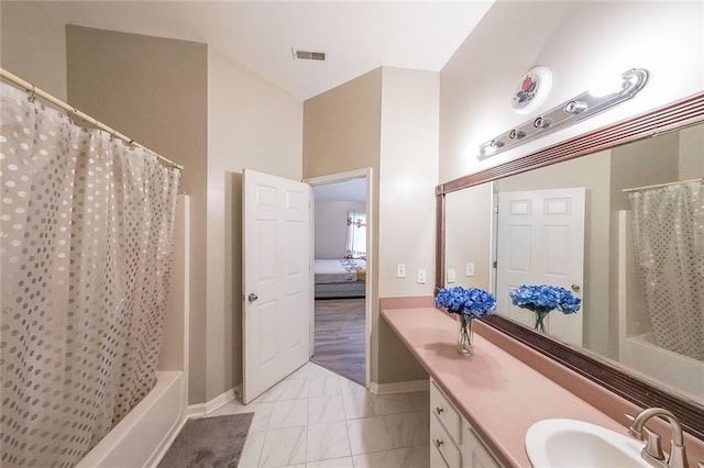 ensuite bathroom with baseboards, visible vents, connected bathroom, shower / bath combination with curtain, and vanity