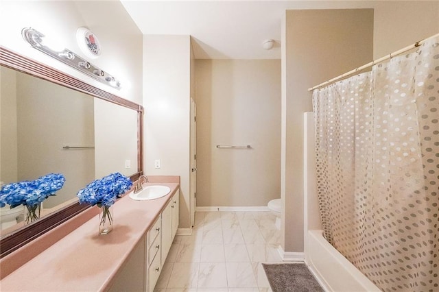 bathroom featuring marble finish floor, baseboards, vanity, and toilet