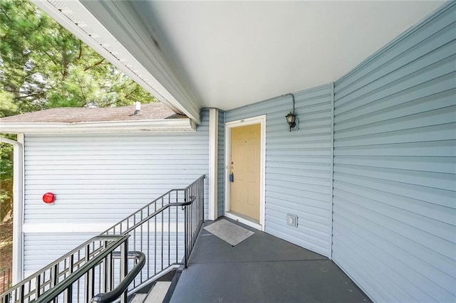 property entrance featuring roof with shingles