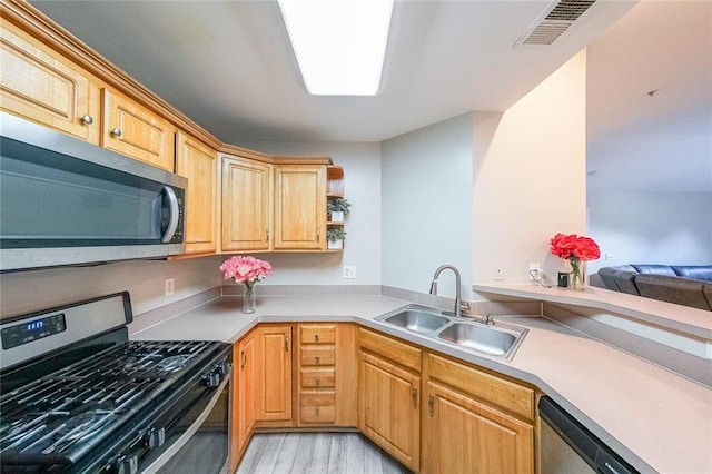 kitchen with a sink, visible vents, light wood-style floors, light countertops, and appliances with stainless steel finishes