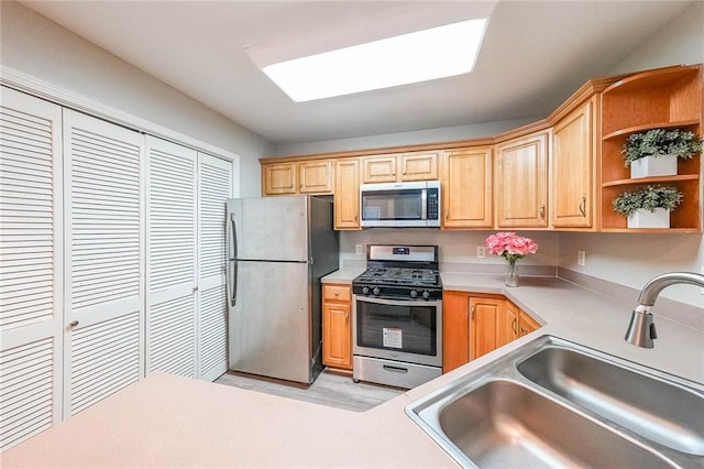 kitchen featuring stainless steel appliances, open shelves, a sink, and light countertops