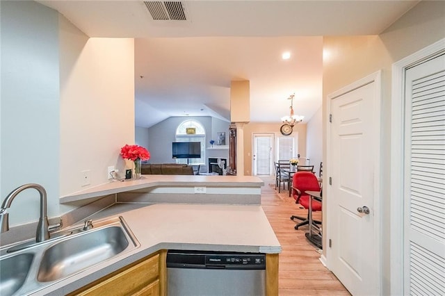 kitchen with light wood finished floors, visible vents, dishwasher, open floor plan, and a sink