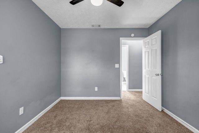 2505 Tiffany Ct SE, Conyers, GA 30013 - carpeted spare room with a textured ceiling, ceiling fan, and baseboards