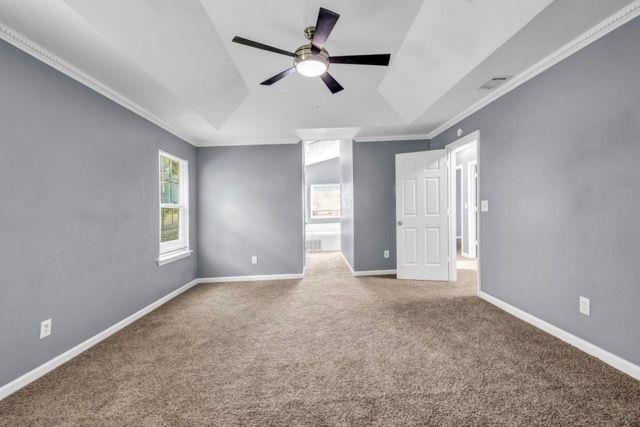 2505 Tiffany Ct SE, Conyers, GA 30013 - carpeted spare room with a ceiling fan, a tray ceiling, ornamental molding, and baseboards