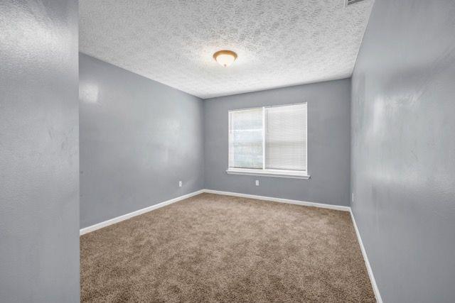 2505 Tiffany Ct SE, Conyers, GA 30013 - empty room featuring carpet flooring, baseboards, and a textured ceiling