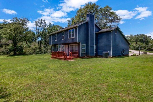 2505 Tiffany Ct SE, Conyers, GA 30013 - rear view of property with a lawn, a chimney, a deck, and central AC