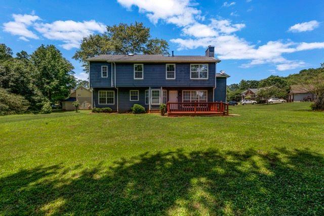 2505 Tiffany Ct SE, Conyers, GA 30013 - rear view of house with a chimney, a lawn, and a wooden deck