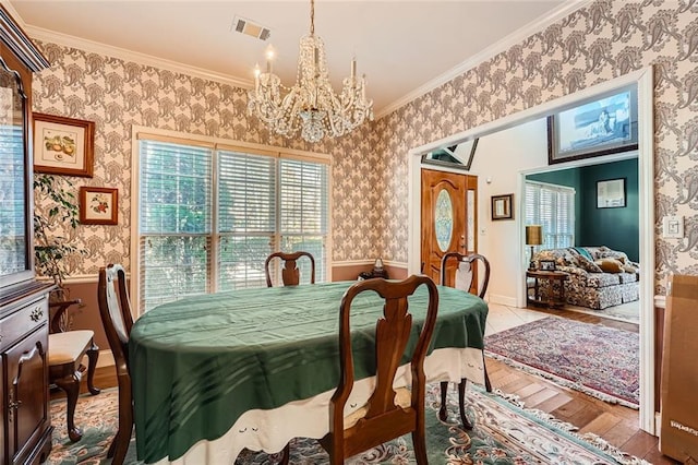 dining area with crown molding, a chandelier, and light wood-type flooring