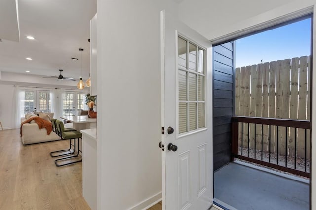 doorway with light wood-style floors, recessed lighting, french doors, and baseboards