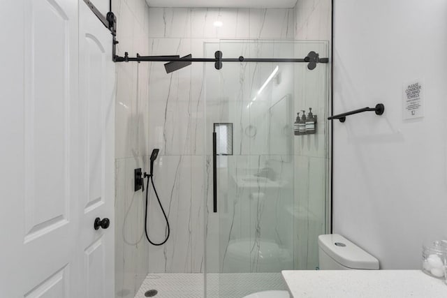 full bathroom featuring toilet and a marble finish shower