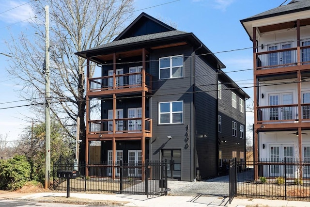 view of front of home featuring a fenced front yard, french doors, and a balcony