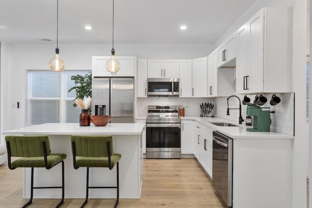 kitchen featuring white cabinetry, appliances with stainless steel finishes, light countertops, and a sink