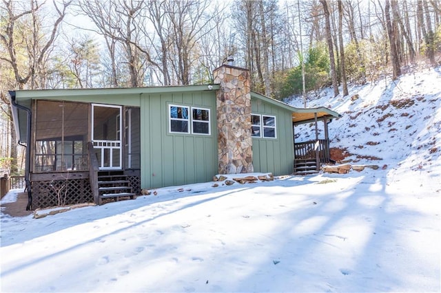 387 Hester Gap Rd, Cleveland, GA 30528 - snow covered house with a sunroom, a chimney, and board and batten siding