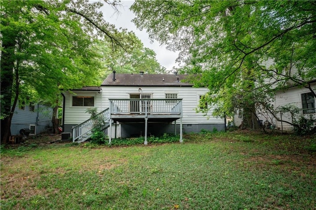 rear view of house featuring a lawn, a deck, and central AC unit