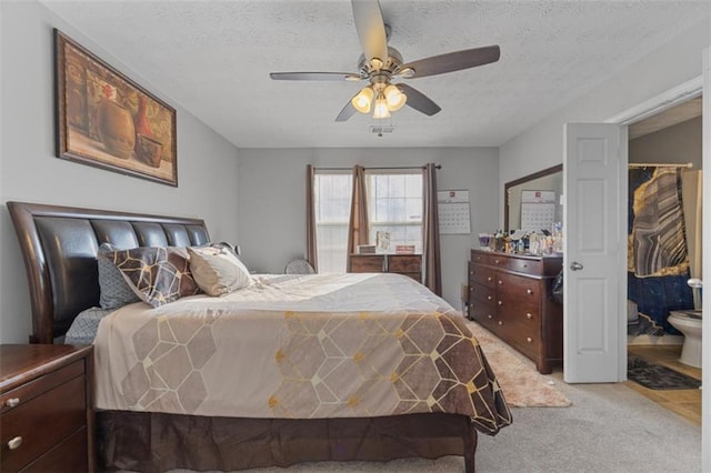 bedroom featuring ceiling fan, light colored carpet, and a textured ceiling