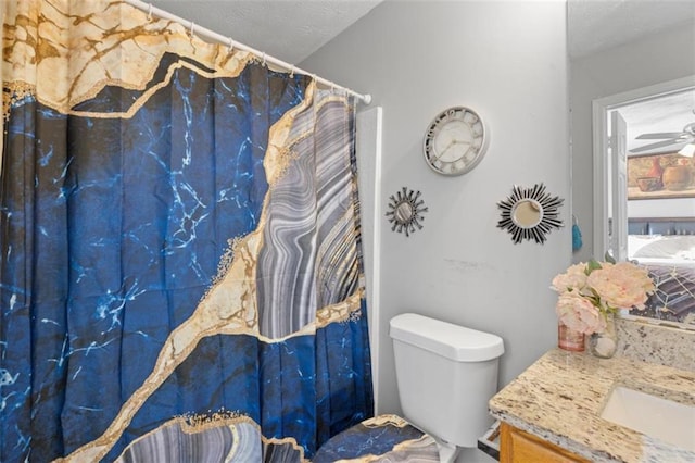 bathroom featuring vanity, a textured ceiling, ceiling fan, and toilet