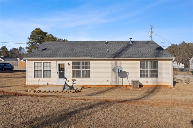 rear view of property featuring central AC unit and a yard