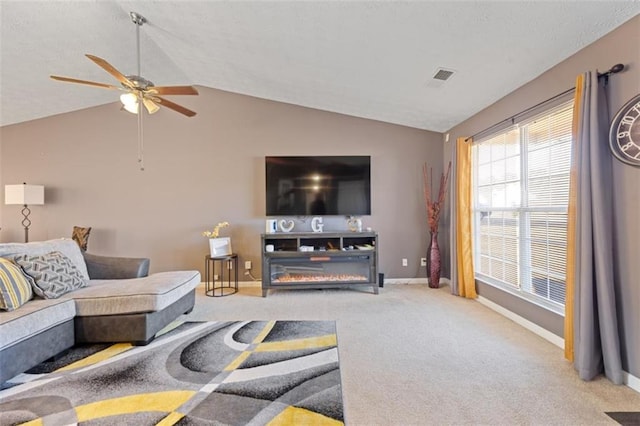 carpeted living room with ceiling fan and vaulted ceiling