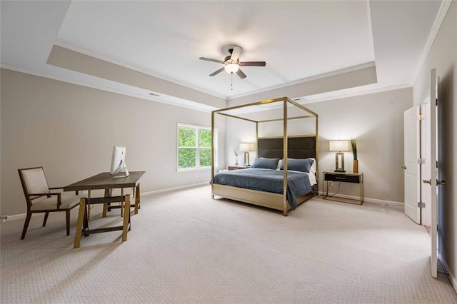 bedroom with light colored carpet, ornamental molding, and a tray ceiling