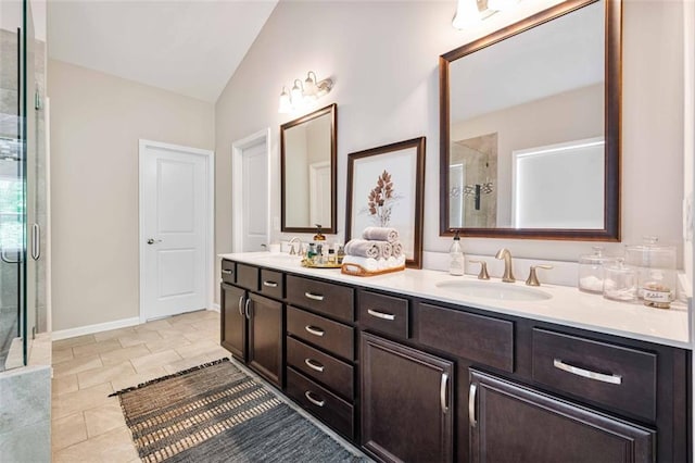 bathroom featuring double vanity, a shower stall, a sink, and lofted ceiling