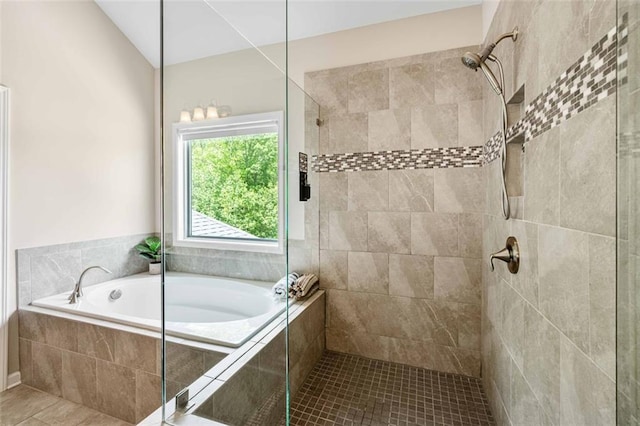 full bath featuring tile patterned floors, a tile shower, and a garden tub