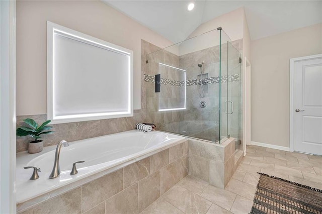 bathroom with baseboards, tile patterned floors, a bath, a shower stall, and vaulted ceiling