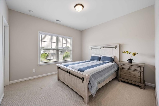 bedroom with baseboards, light carpet, and visible vents