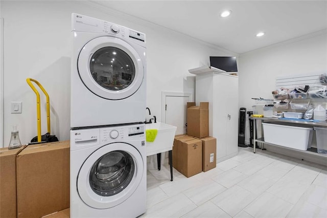 laundry area with laundry area, stacked washer and dryer, crown molding, a sink, and recessed lighting