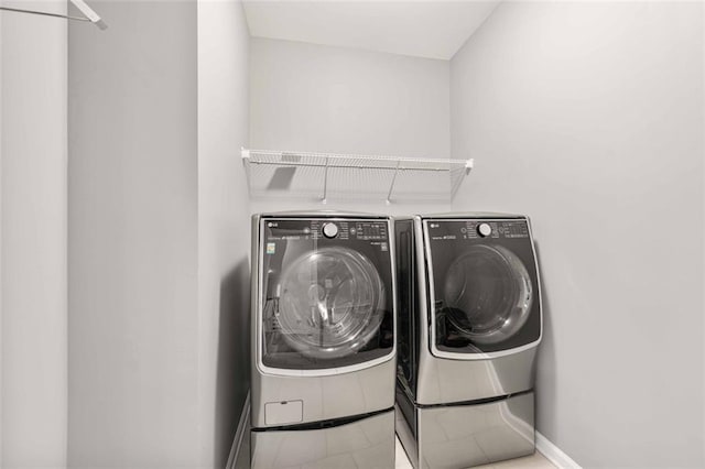 washroom with washer and dryer, laundry area, and baseboards