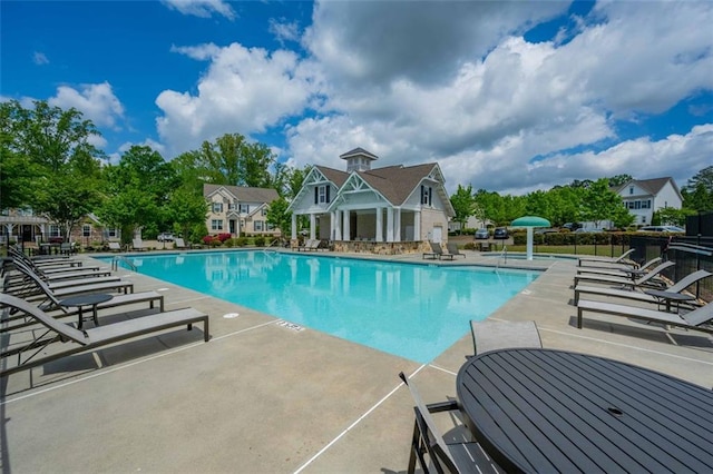 community pool featuring a patio and fence