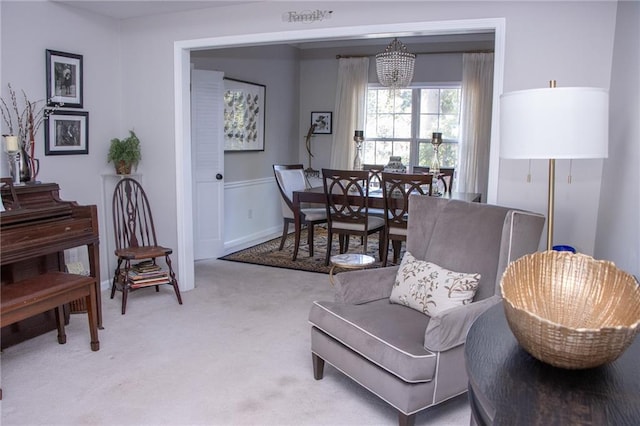 living area with light colored carpet and a notable chandelier