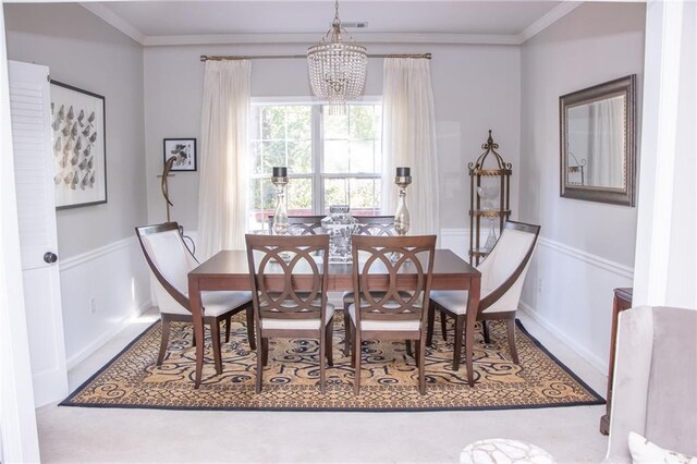 carpeted dining room with crown molding and a chandelier