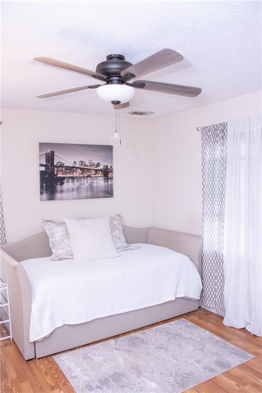 bedroom with ceiling fan and hardwood / wood-style floors